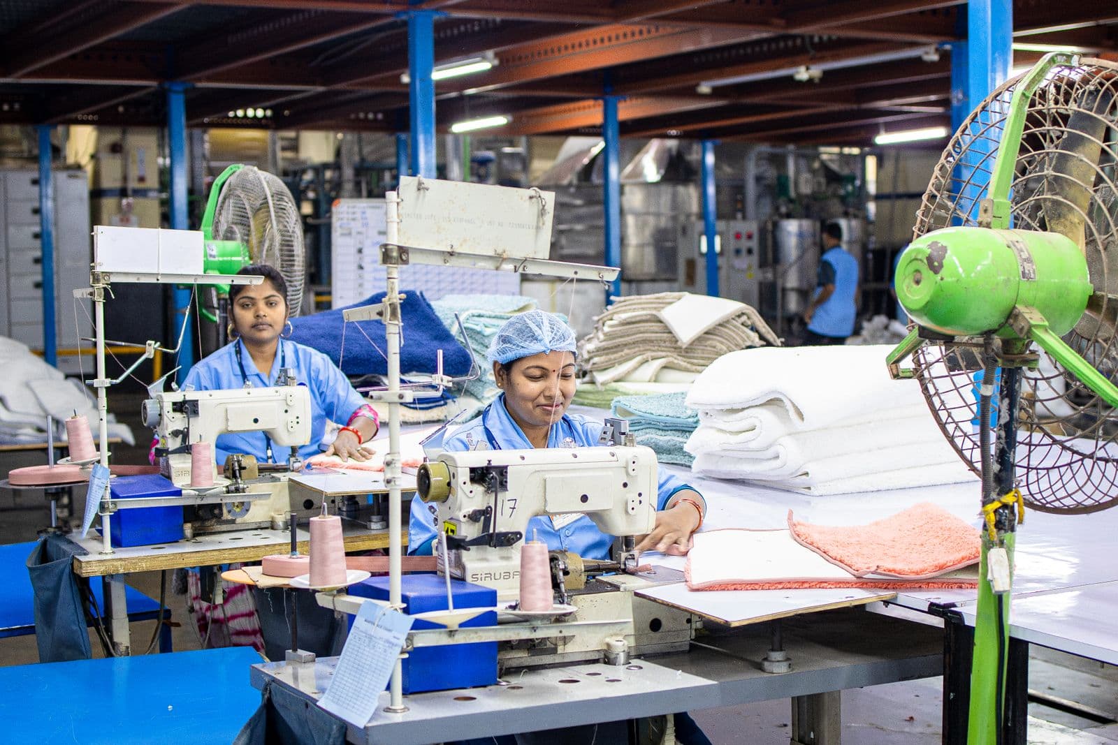 Garment workers sewing and finishing textiles on a production floor